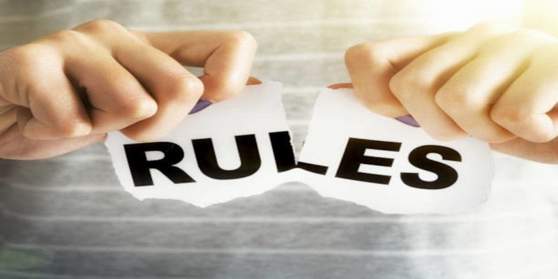 Picture of two hands tearing apart a letter that says “rules”.