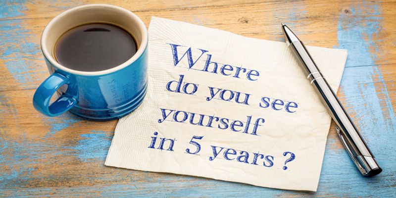 Where do you see yourself in 5 years? Handwriting on a napkin with a cup of espresso coffee.