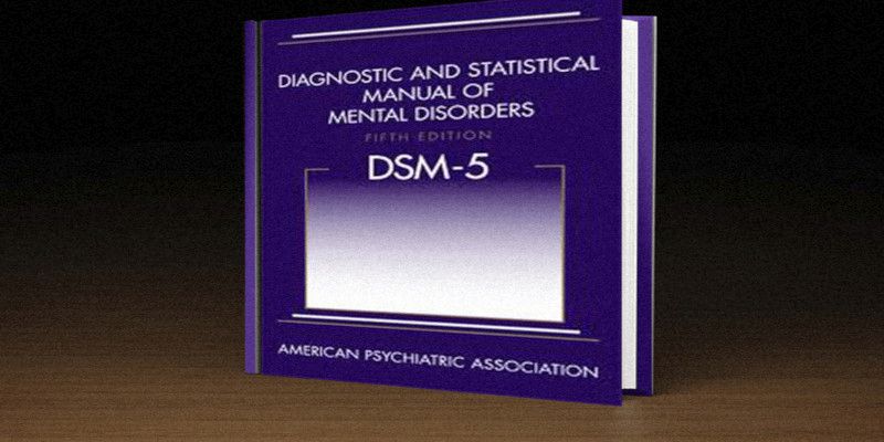 Picture showing a purple DSM-5 book on a brown background.