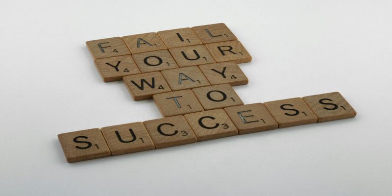 The sentence, “Fail your way to success” made with scrabble blocks.
