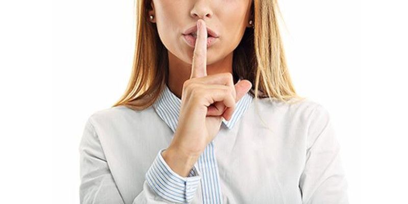 Image of a woman holding her finger in front of her mouth, signifying to be silent.