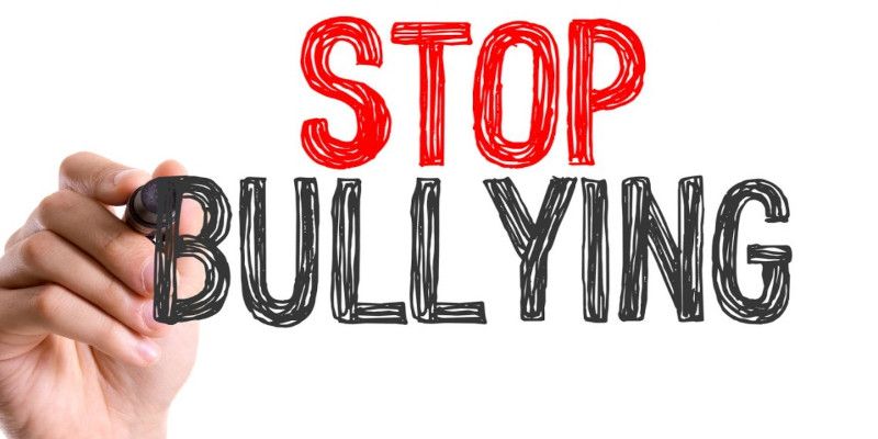 Image of the words, “stop bullying” being written by someone's hand holding a marker.
