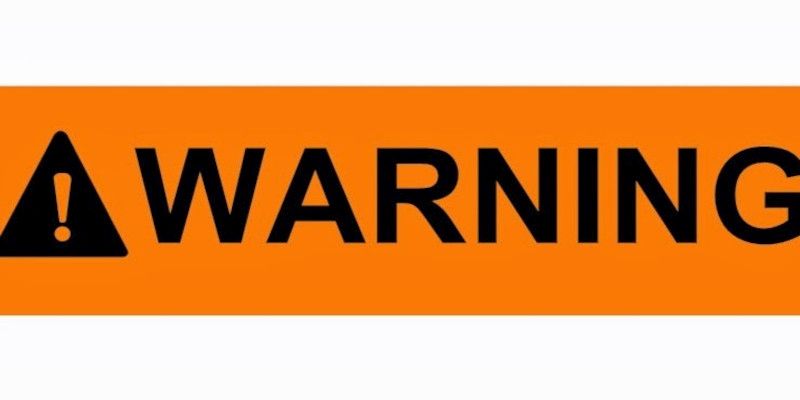 Image of a black warning sign with the word “warning” written in black on a yellow background.