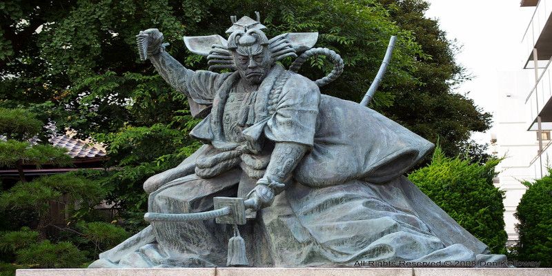 Image of a samurai warrior statue in a garden.