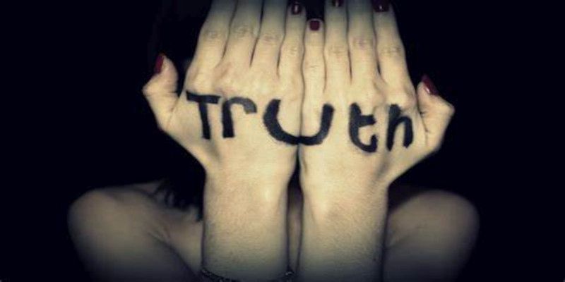 Image of someone holding their hands in front of their face with the word 'truth' written on the back of their hands.