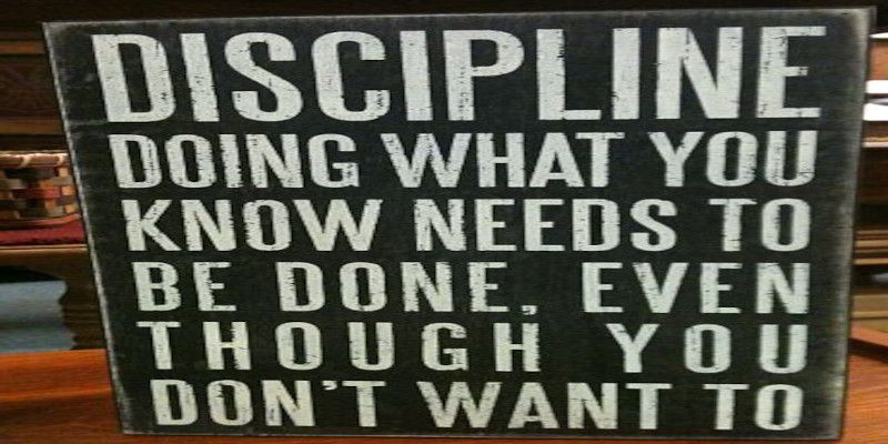 A sign reading, “discipline, doing what you know needs to be done, even though you don't want to.” Written in white letters on a black background.