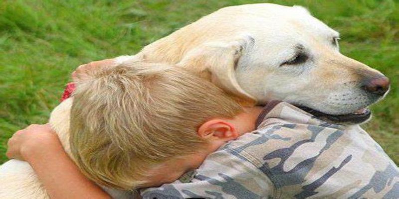 Picture of a kid hugging an emotional support dog.