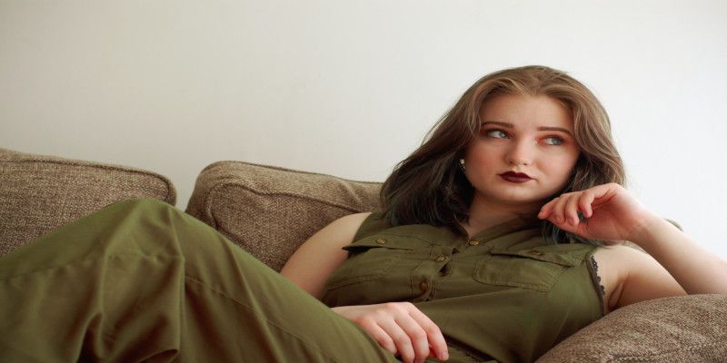 Image of a young woman lying in a couch doing nothing.