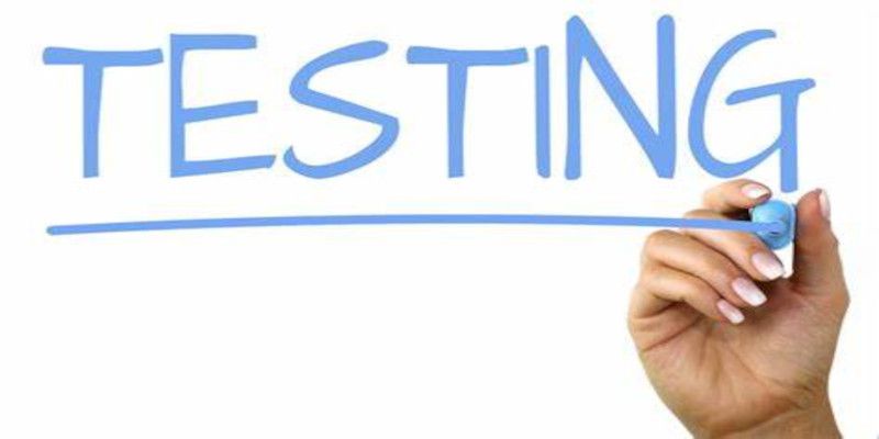 Image of the word “testing” being written by someone's hand with a blue marker on a white background.