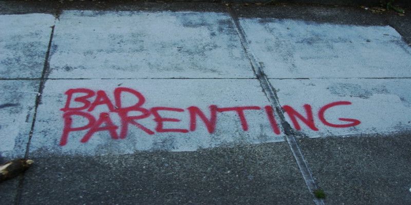 The words, “bad parenting” sprayed in red paint on the pavement.