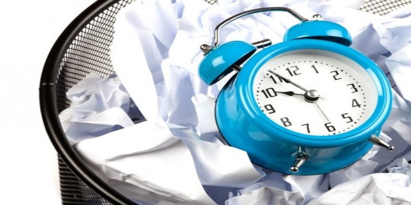 Image of a blue clock lying in the bin, indicating that it's a waste of time.
