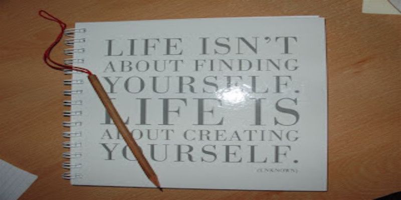 The quote, “life isn't about finding yourself. Life is about creating yourself.” written on a notebook.