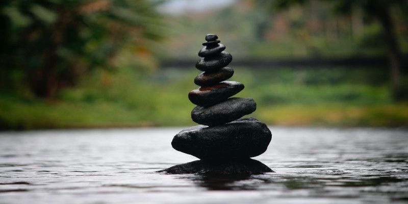 Image of stones resting on top of each other in the water.