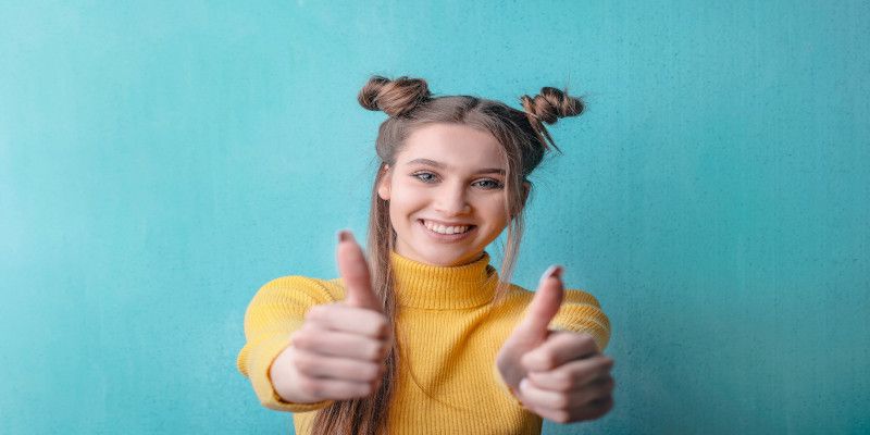 Young woman giving a double thumbs up.